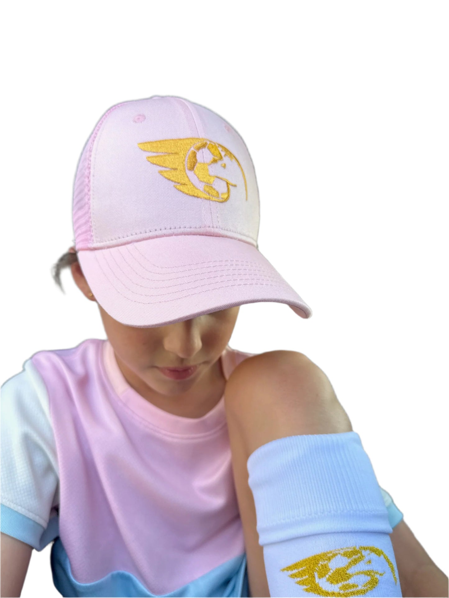 Pink trucker cap with gold embroidery, featuring mesh back and snapback closure, worn by person inside a vehicle.