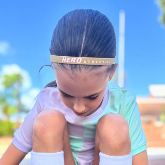 Child wearing Hero Athletica head band with silicone grip during outdoor sports.